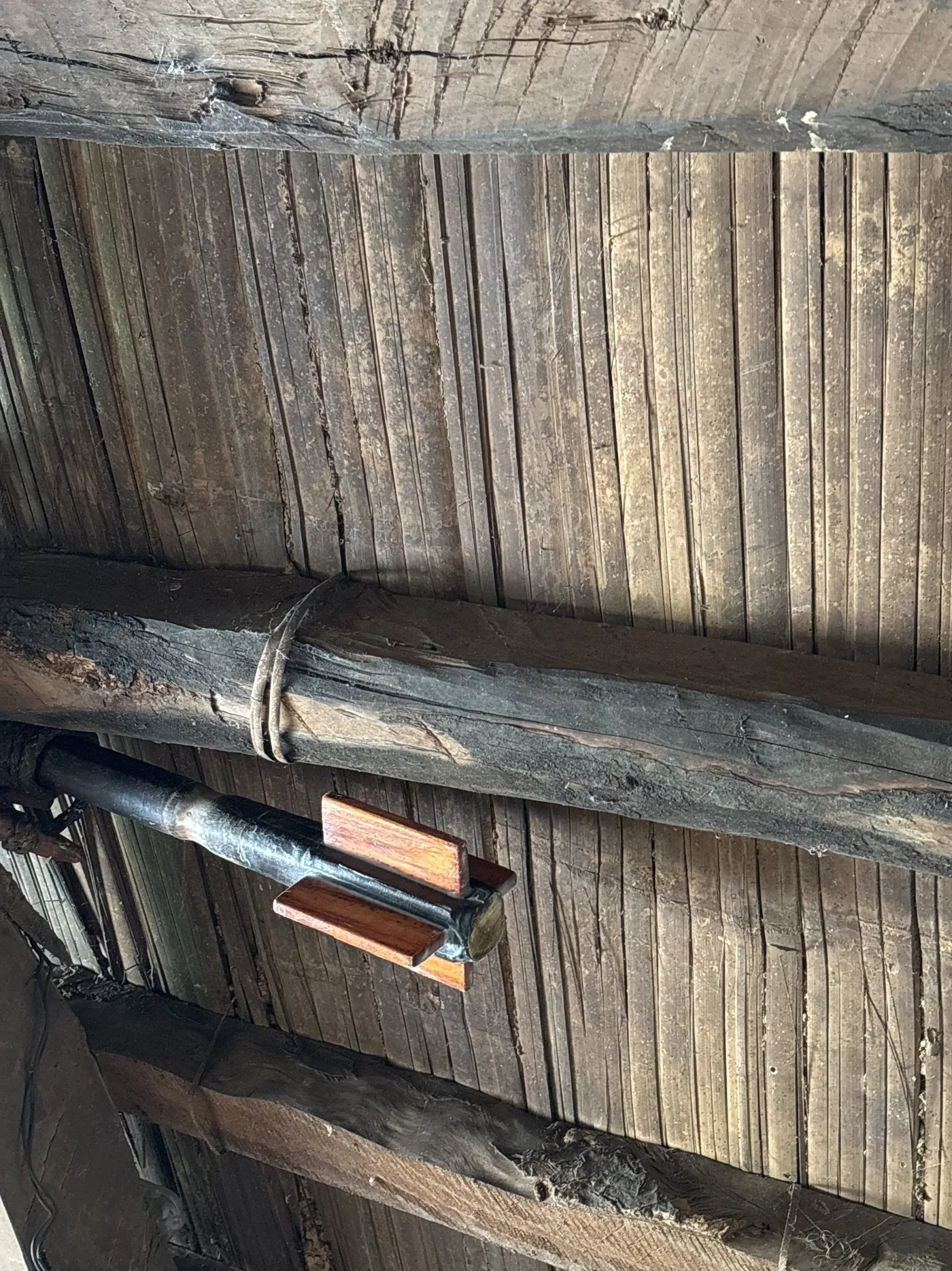 Split, weathered deck boards with a rusted bolt through them