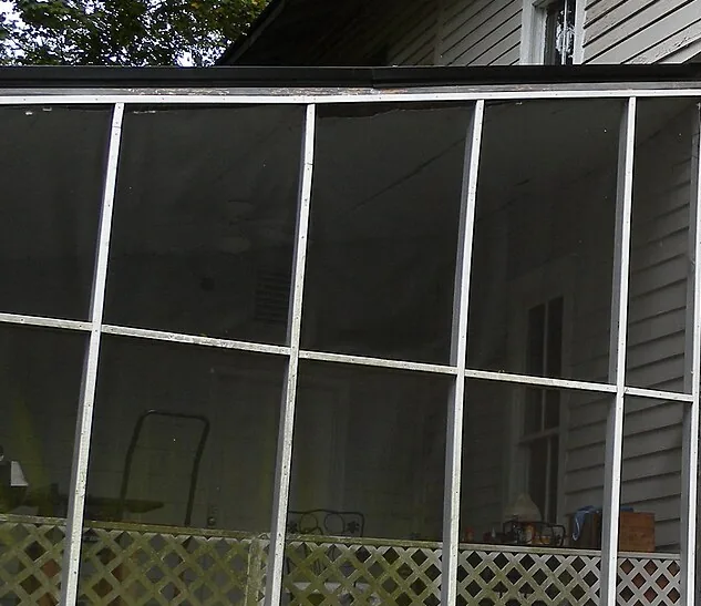 Screened porch wall with mesh panels above a lattice knee wall